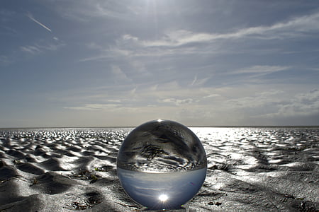 round clear glass ball on sand thumbnail