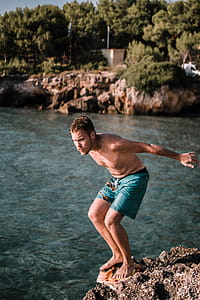 Photo of Man Standing on Rock Cliff in Front thumbnail