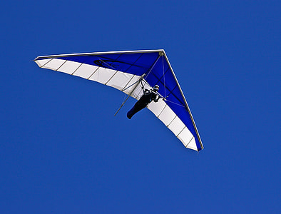 person riding blue and white paraglider in clear sky thumbnail