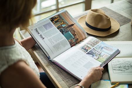 photo of woman holding opened book on top of table thumbnail