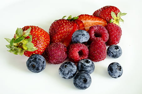 grasp berries, blueberries, and strawberries on top of white surface thumbnail