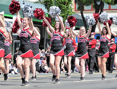 cheerleader women dancing on road during daytime thumbnail