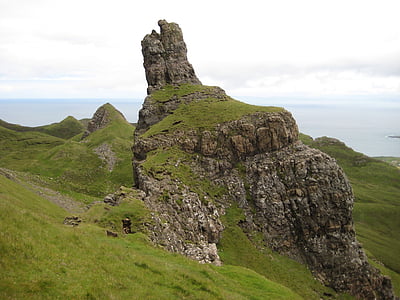 cliffside covered with green grass under white clouds at daytime thumbnail