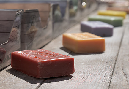 closeup photography of five assorted-color soaps on gray wooden plank thumbnail