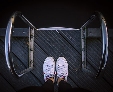 person standing on black wooden dock thumbnail