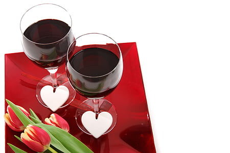 two wine glass with red wine inside beside tulip flowers thumbnail