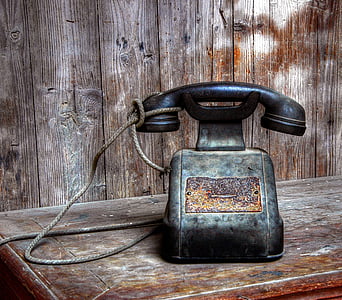 black cradle phone on brown wooden desk thumbnail