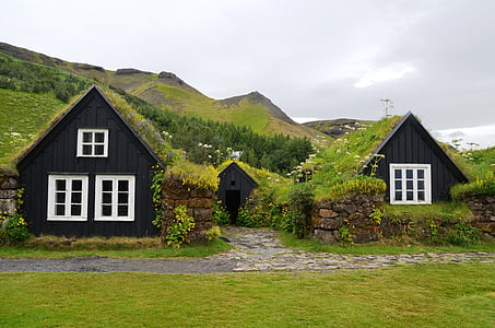 two black painted houses across green mountain thumbnail