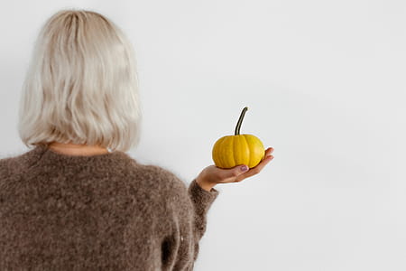 Women's hands in sweater are holding pumpkin thumbnail