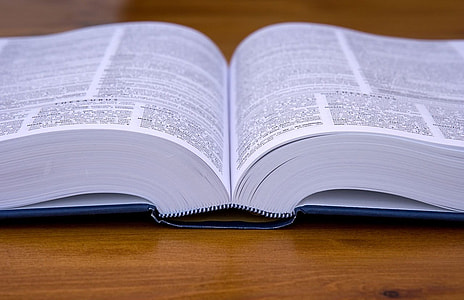 opened book on brown wooden table thumbnail