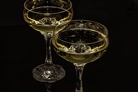 two clear cocktail glasses on black surface close-up photo thumbnail