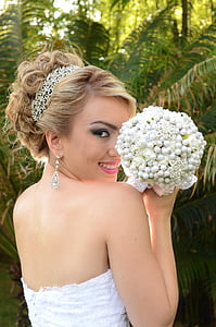 bride in white gown holding bouquet of white flowers thumbnail