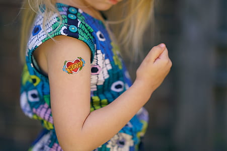girl in blue dress showing tattoo on right arm thumbnail