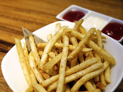 fries with sauce on bowl placed on wood plank thumbnail