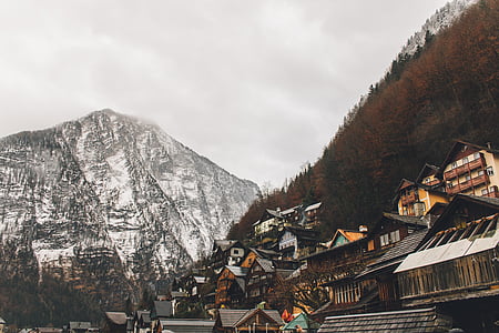 brown and yellow wooden houses near mountain thumbnail