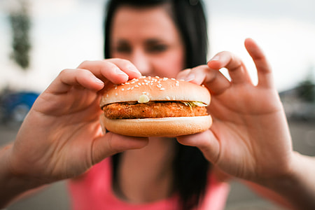 Girl holding Hamburger in her Hands thumbnail