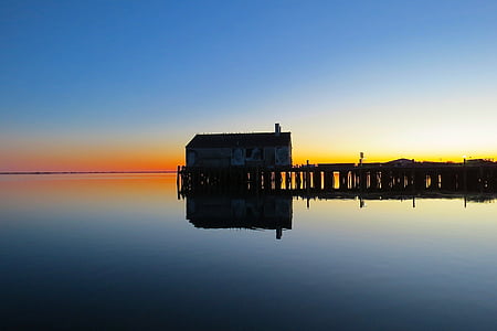 brown wooden house in the middle of body of water thumbnail