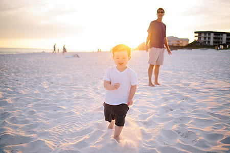 boy in white v-shirt on top of white sand thumbnail