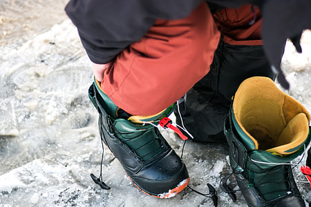 person wearing pair of black snow boots thumbnail