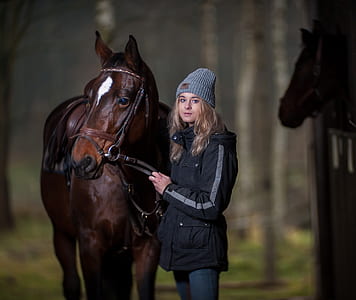 woman standing beside brown horse on stable thumbnail