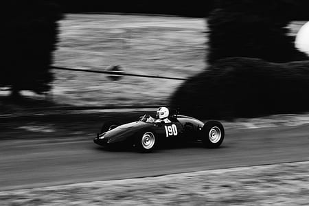 grayscale photo of a person riding a race car thumbnail