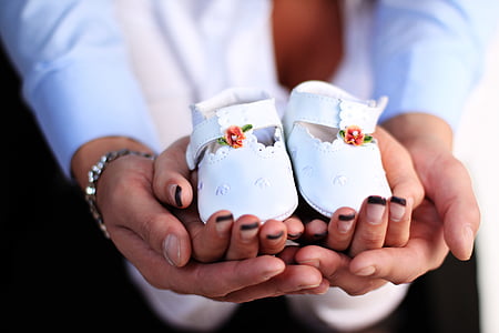close-up photography of pair of baby's white leather shoes on persons hand thumbnail