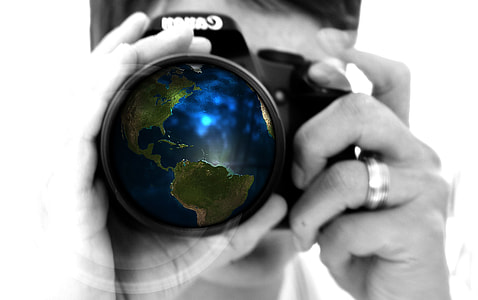 macro photography of man with DSLR camera with globe lens display thumbnail