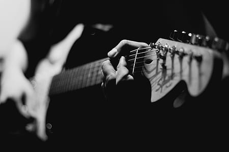 grayscale photo of man holding electric guitar thumbnail