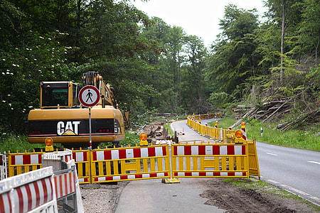 yellow excavator on side of road inside yellow barrier at daytime thumbnail