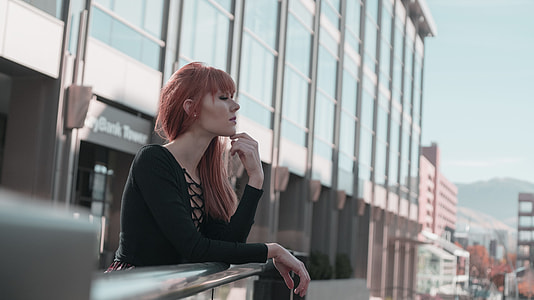 selective focus photography of woman leaning on silver railings thumbnail