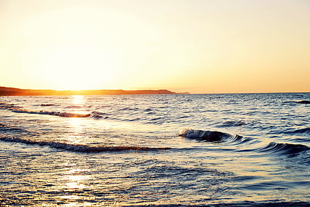 silhouette of island by ocean photo taken during golden hour thumbnail