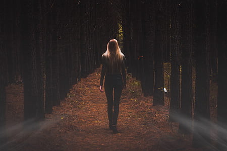 woman walking surrounded by trees thumbnail