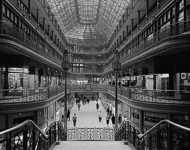 grayscale photo of people walking beside store facades thumbnail