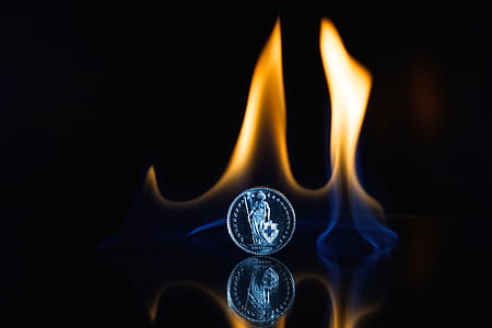 Round Silver-colored Coin on Black Surface With Flame thumbnail