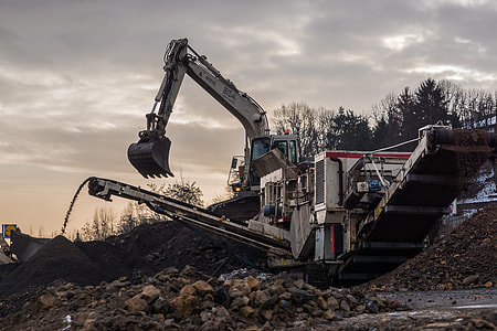 white heavy equipment beside trees thumbnail