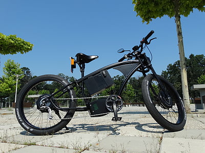 black cruiser bike parked on gray tiled pavement thumbnail