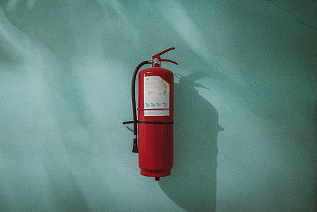 red fire extinguisher on green background thumbnail