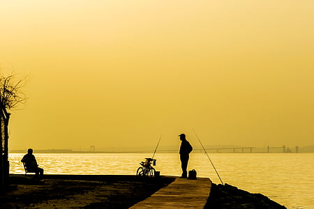 silhouette o man standing in front of body of water thumbnail
