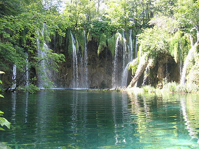 waterfalls between green trees during daytime thumbnail