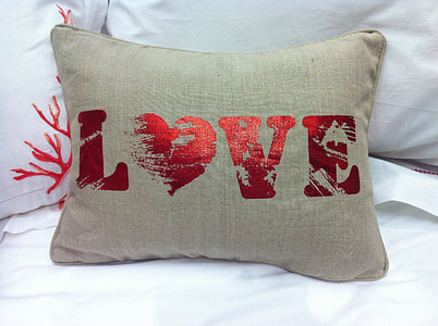 brown and red love pillow on white bed thumbnail