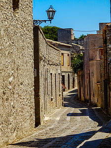 pathway between brown buildings thumbnail