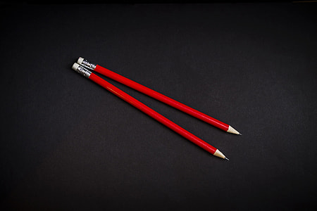 two red pencils on black panel thumbnail