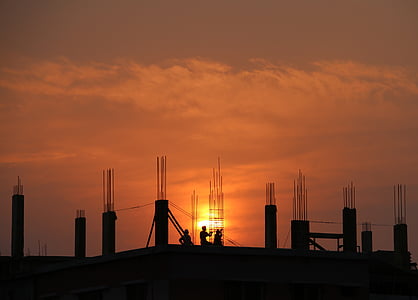 silhouette photography of three men on construction site during golden hour thumbnail