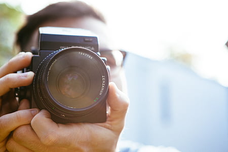 person using black DSLR camera thumbnail