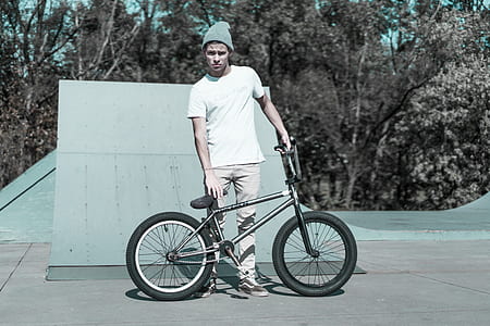 man standing beside black BMX bike thumbnail