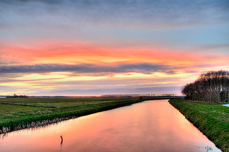 panoroma photography of green grass land beside canal during golden hour thumbnail
