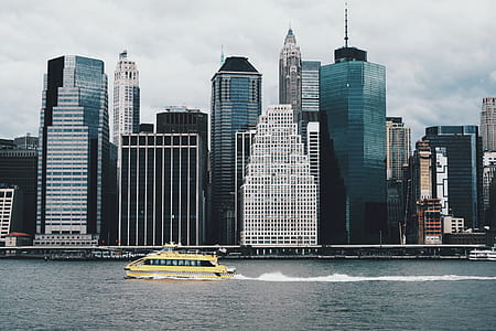 white boat on water near city during cloudy day thumbnail