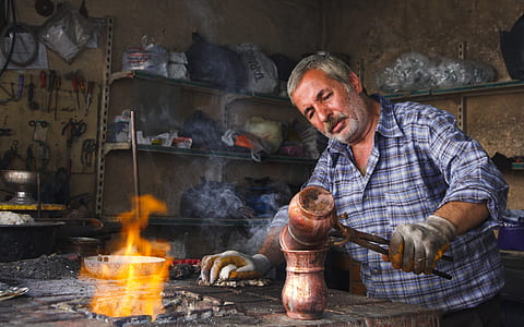 man holding melting pot near flame thumbnail