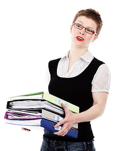 woman wearing black and gray polka-dotted collared shirt carrying four file binders thumbnail
