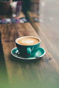 tilt-shift photography of cappuccino in teal coffee mug thumbnail